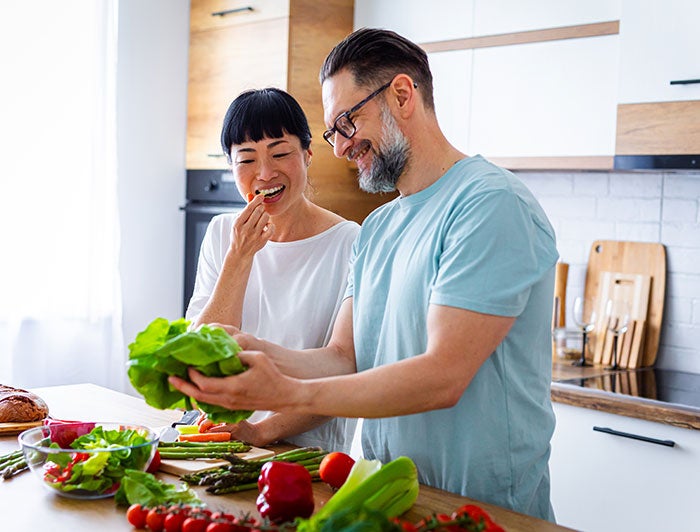 Middle aged couple eating vegetables in a kitchen; Texas Health Presbyterian Hospital Kaufman program focuses on healthy eating to manage chronic diseases
