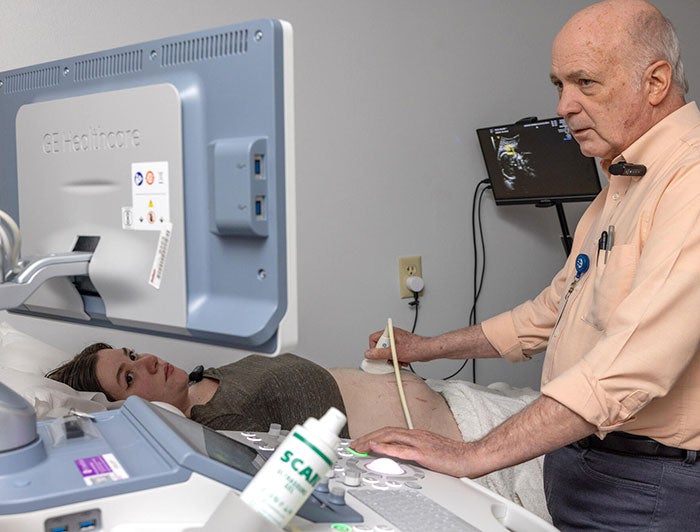 A doctor performs a sonogram on a pregnant woman