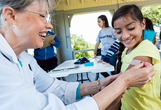 health worker treats a young girl at a mobile clinic