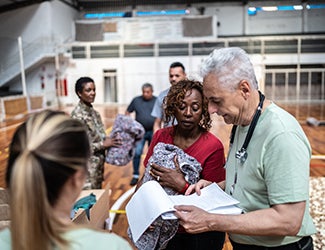 doctors, National Guardsmen and administrators hand out disaster relief supplies in a school gymnasium