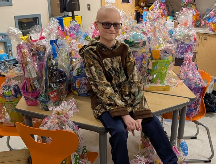 Nathan Yuill sits amidst Easter baskets