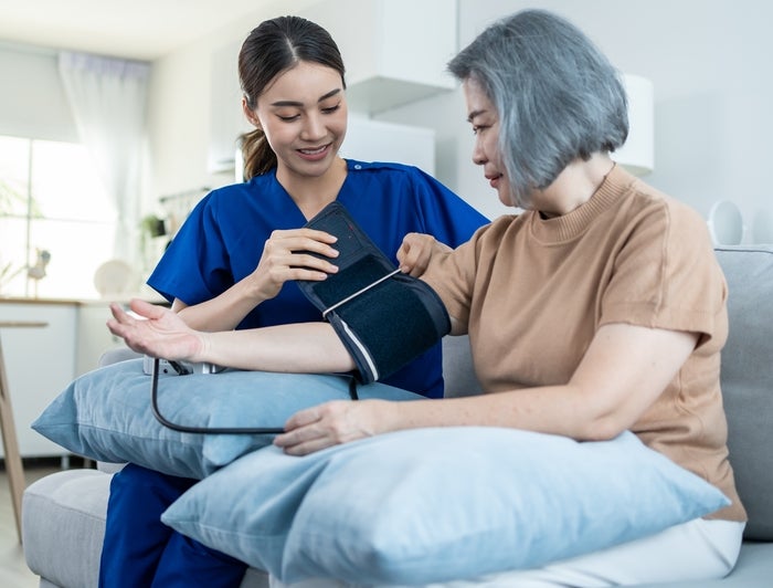 Senior patient sitting on table having blood pressure checked