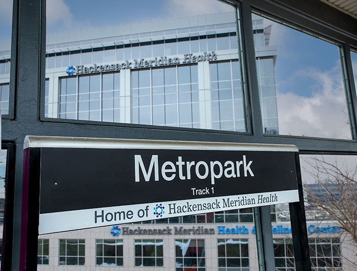 Metropark rail station sign features Hackensack Meridian health logo