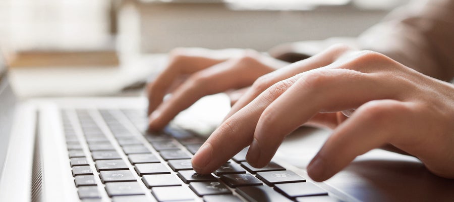 Fingers type on a keyboard