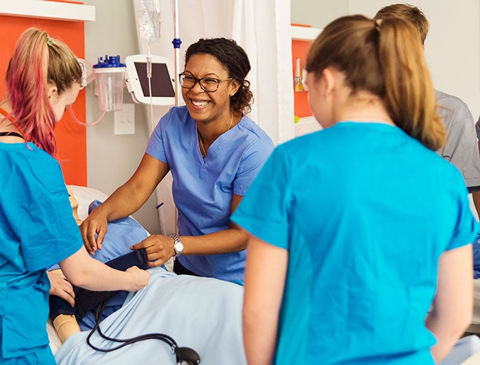 A nurse and trainees at patient bedside