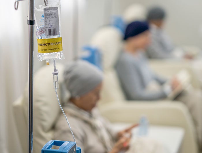 Drug infusion bag in focus with health worker in background