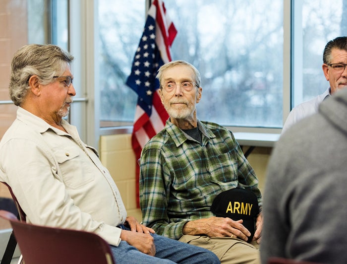 older veterans sit in a group therapy session