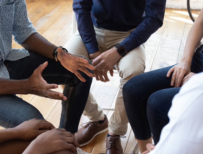 people sit close together in a therapy circle talking