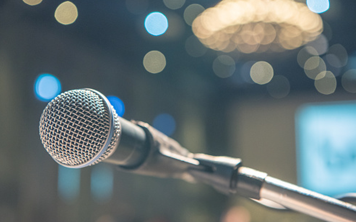 Call for Speakers: 2027 AHA Rural Health Care Leadership Conference. A microphone on stage at the AHA Rural Health Care Leadership Conference.