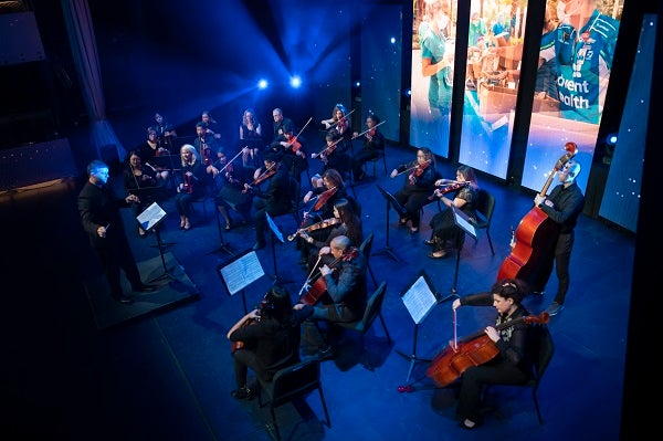 The AdventHealth Orchestra playing on stage.