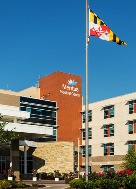Meritus Medical Center hospital facility with the Maryland state flag flying in front of it.