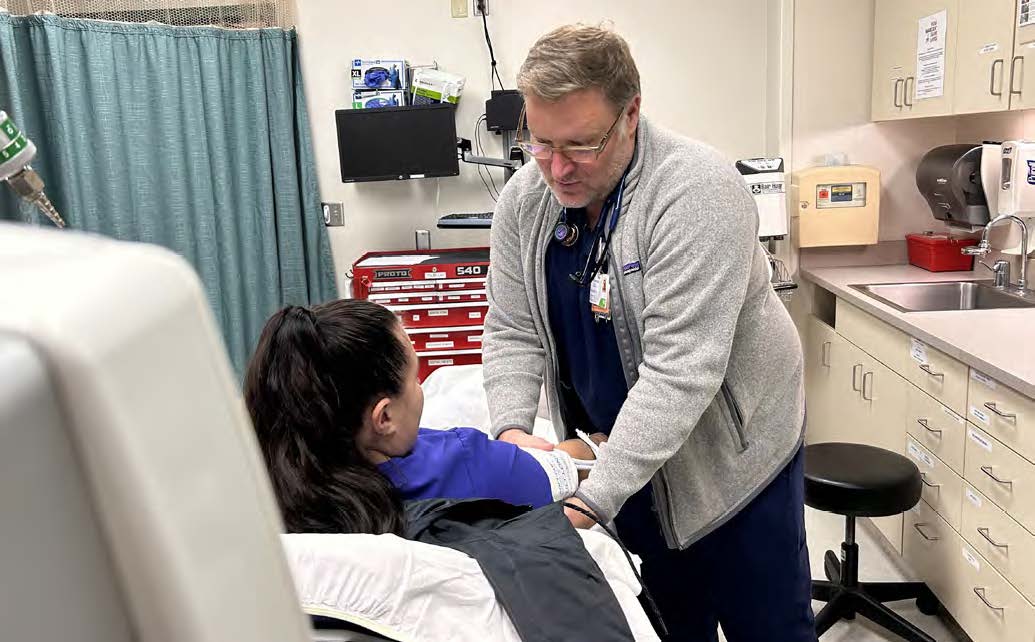 Providence, Washington. A clinician takes a patient's blood pressure in an examination room.