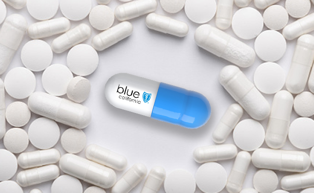 Will Blue Shield’s New Pharma Model Disrupt the PBM Market? A blue and white capsule with Blue Shield of California's logo on it surrounded by white generic pills and capsules.