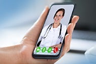 AHA Market Scan Could We See $250 Billion in Care Virtualized? A patient holds her phone in her left hand and speaks to her doctor via a telehalth app.