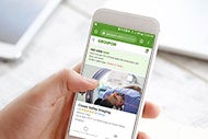 AHA Market Scan Need a Deal on MRI or CT Scan? Grab a Coupon. A person's hand holding a mobile phone to download a health care coupon.