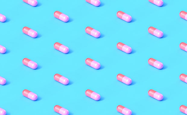 Will Startup PBMs Drive Drug Price Transparency? Drug capsules aligned in in straight rows and columns on a blue background.