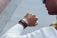 AHA Market Scan Fitbit Forms Its First Partnership with Medicaid Plan. A man looking at his Fitbit on his left wrist.