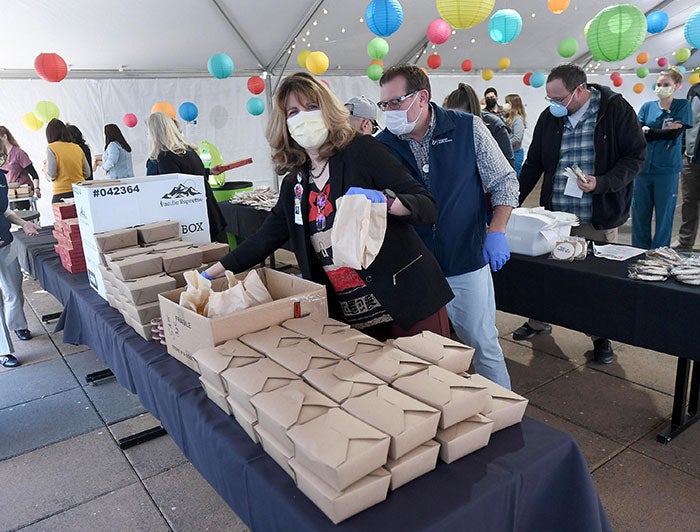 Samaritan Health Services. People at a celebration with boxed lunches and other food.