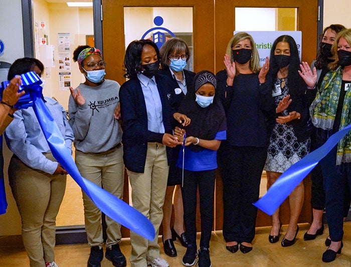 ChristianaCare Brings Quality Health Care to Students. Students wearing masks from Kuumba Academy Charter School cut the blue ribbon to open their new health center.