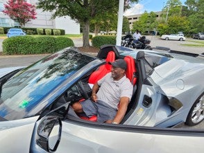 Corvette Club member shows off a silver Corvette convertible.