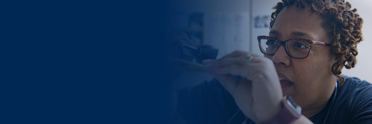 A clinician examines a patient's throat using a tongue depressor and a light.