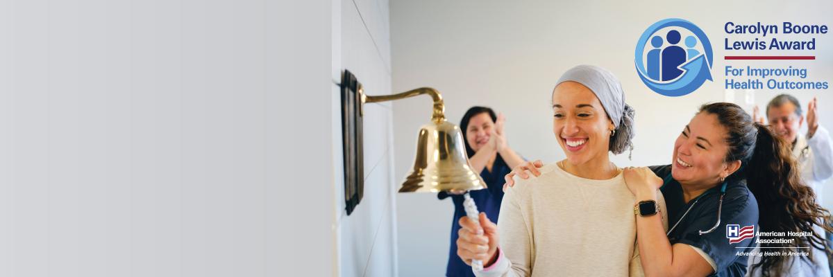 Cancer patient ringing the remission bell as care team celebrates with her
