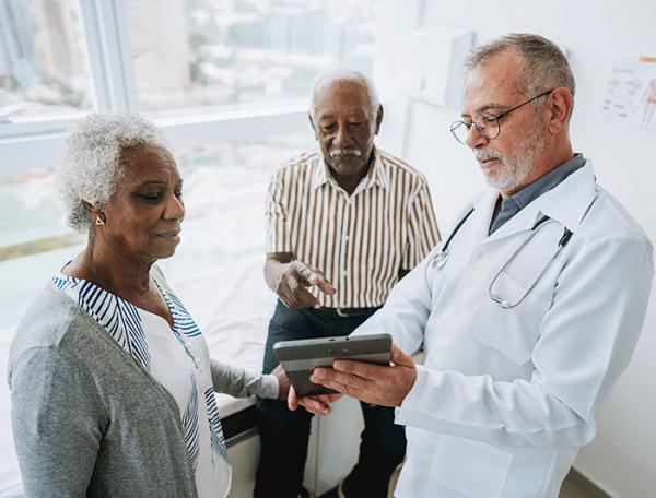 A doctor speaks with an older female patient