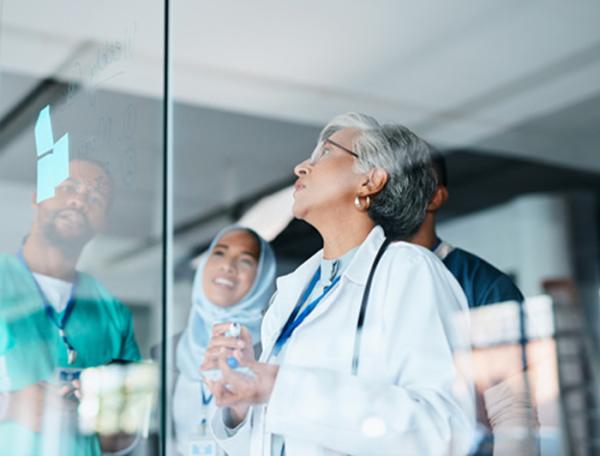 A diverse medical teamreviews notes.