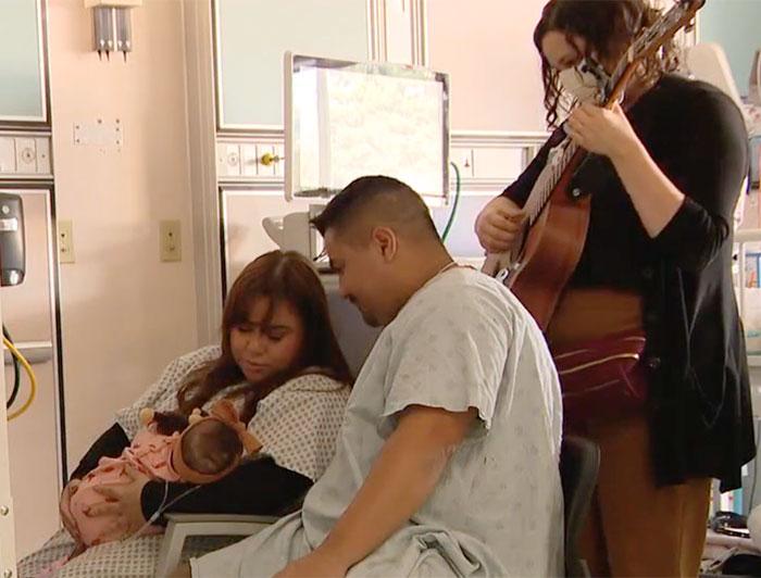Musicians play for a couple and their baby