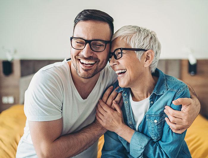 Stock. A laughing man and woman share a friendly hug 