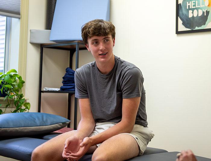 UVMC patient Kian sits in a doctor's office exam room