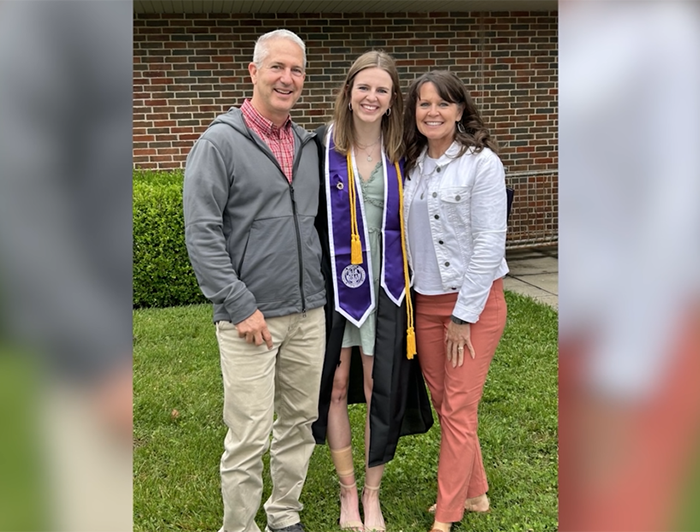 Madeleine Gillman stands with her parents at her college graduation