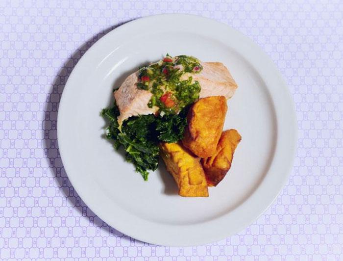Salmon, greens and sweet potato on a white dinner plate