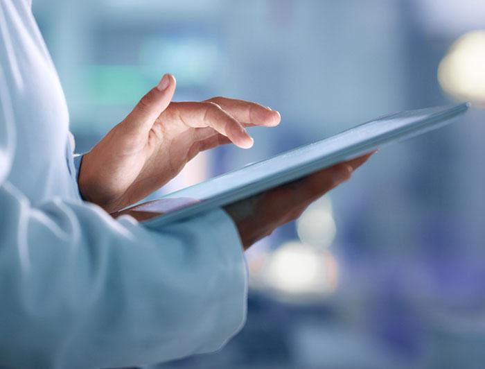 A clinician at Artesia General Hospital uses Microsoft Dragon Copilot, an AI-powered clinical assistant that records patient conversations, transcribes them, and updates electronic health records automatically.