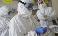 Virginia Hospital’s COVID-19 Triage Model May Pay Dividends Even after the Pandemic. Clinicians treating COVID-19 patients don personal protective equipment (PPE) before treating patients.