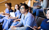 Why Community Colleges Can Be a Powerful Resource to Strengthen the Clinical Workforce Pipeline. A diverse group of clinicians in a classroom raptly pay attention to a presentation.