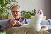 UPMC’s App to Lower Post-Surgery Readmission Rates Is a Pip. A patient elevated his right leg which is in a cast uses the UPMC Enterprises and Redesign Health Pip Care Inc. app on his mobile phone for post-surgical coaching.
