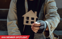 Trinitas Regional Medical Center Is Addressing Homelessness and Getting Results. A homeless man presents a house cut out of cardboard. AHA Member Spotlight.